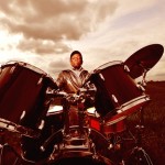 Tony Allen (Bernard Benant) playing drums in field landscape